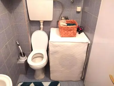 a bathroom with a toilet and a basket on a counter at Flat in Belgrade city center, 45m2 in Belgrade