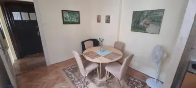 a dining room table with chairs and a phone at Apartman Valdano in Belgrade