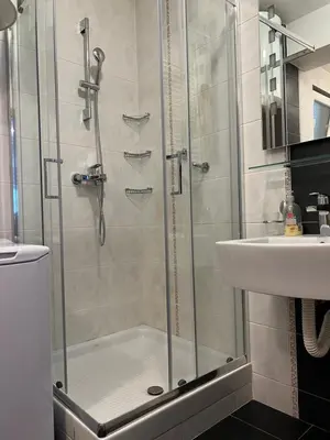 a shower with a glass door next to a sink at Apartment Vračar in Belgrade