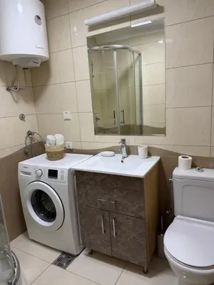 a bathroom with a washing machine and a sink at Apartment Arena Lux in Fontana