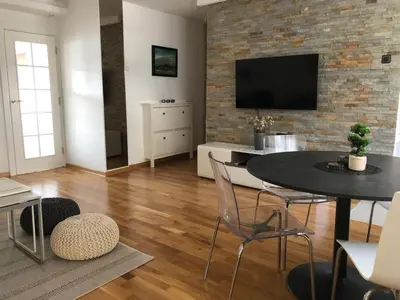 a living room with a table and a brick wall at Apartment Arena Lux in Fontana