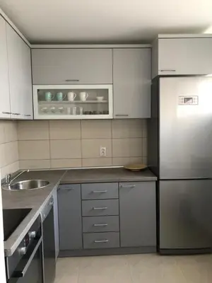 a kitchen with white cabinets and a stainless steel refrigerator at Apartment Arena Lux in Fontana