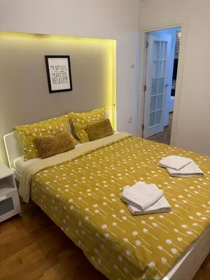 a bedroom with a yellow bed with towels on it at Apartment Arena Lux in Fontana