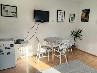 a kitchen with a table and chairs and a tv on the wall at Apartment in the downtown - walking distance all attractions in Belgrade