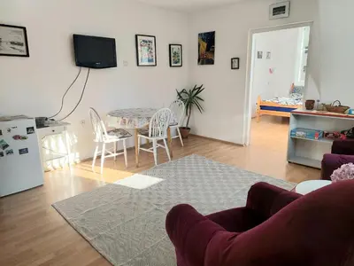 a living room with a table and chairs and a kitchen at Apartment in the downtown - walking distance all attractions in Belgrade