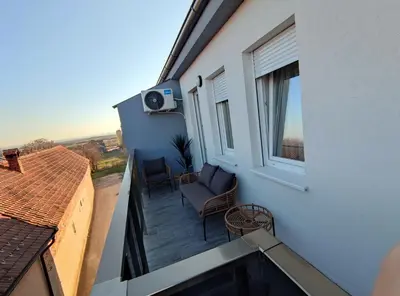 a balcony with a couch and a window at BellaCasa AirportStudio in Surčin