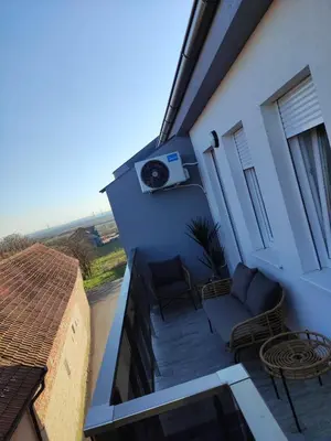 a balcony of a house with a couch and a table at BellaCasa AirportStudio in Surčin