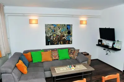a living room with a gray couch with colorful pillows at Charming and stylish centrally located 50m2 in Belgrade