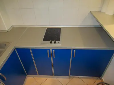 a kitchen counter with a stove and blue cabinets at Apartment Grmech in Novi Beograd