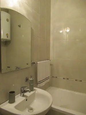 a white bathroom with a sink and a bath tub at Apartment Grmech in Novi Beograd