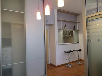 a room with a glass closet and two stools at Apartment Grmech in Novi Beograd