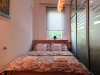a bedroom with a bed with two pillows and a window at Apartment Grmech in Novi Beograd