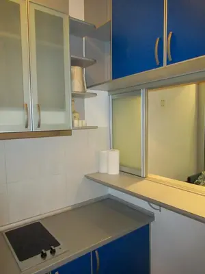 a kitchen with blue and white cabinets and a counter at Apartment Grmech in Novi Beograd