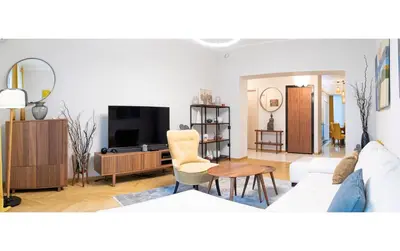 a living room with a white couch and a tv at Dani City Center Apartment in Belgrade