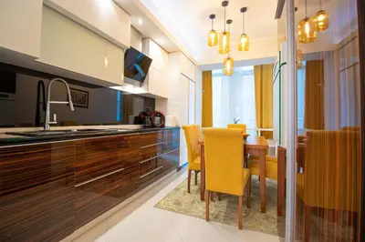 a kitchen and dining room with a table and chairs at Dani City Center Apartment in Belgrade