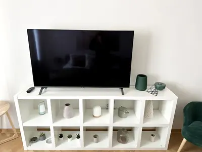 a white entertainment center with a flat screen tv on it at Dani City Center Apartment in Belgrade