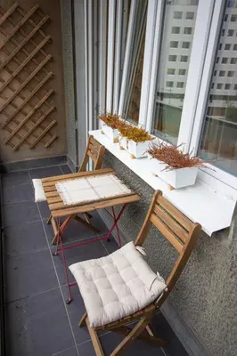 a table and chairs on a balcony with plants at Dani City Center Apartment in Belgrade
