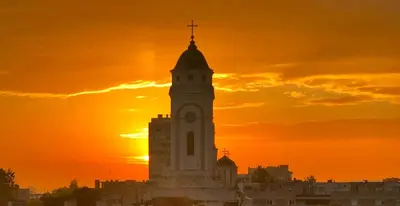 a clock tower with a sunset in the background at Sokolov Apartment in Smederevo