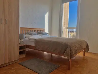 a bedroom with a bed and a large window at Sokolov Apartment in Smederevo