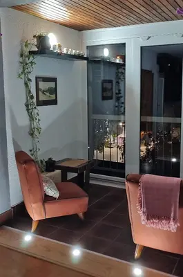 a living room with two chairs and a large window at Sokolov Apartment in Smederevo