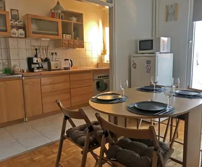 a kitchen with a table and chairs with wine glasses at Sokolov Apartment in Smederevo