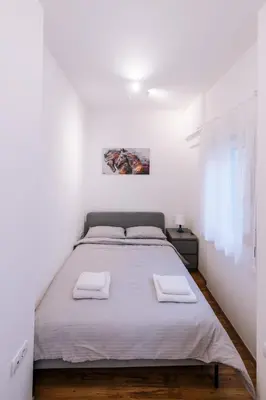 a white bedroom with a bed with two towels on it at Marshal Nbg in Belgrade