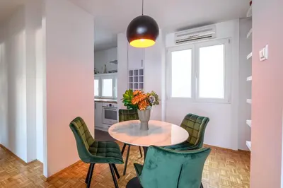 a kitchen with a table and green chairs at Marshal Nbg in Belgrade