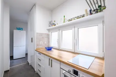 a kitchen with white cabinets and a wooden counter top at Marshal Nbg in Belgrade