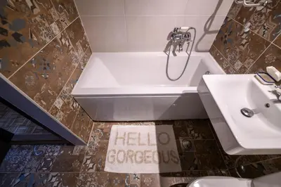 a bathroom with a tub and a sink and a hello congress sign at Marshal Nbg in Belgrade
