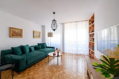 a living room with a green couch and a table at Marshal Nbg in Belgrade