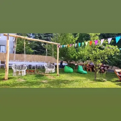a park with a swing and a playground with flags at Kosmajski raj in Nemenikuće