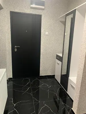 a bathroom with a black door and a black tile floor at Lana in Arandjelovac