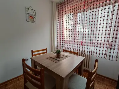 a dining room table with chairs and a window at Banjica 2 in Voždovac