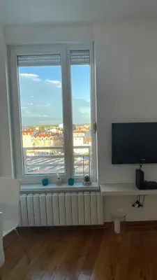 a living room with two windows and a flat screen tv at Luka 1718 Apartments in Belgrade