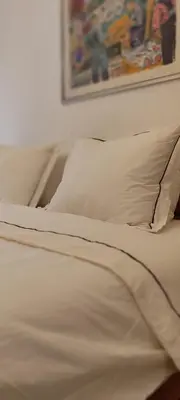 a white bed with two pillows and a picture on the wall at Luka 1718 Apartments in Belgrade