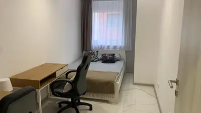 a small bedroom with a bed and a desk and a chair at Jevtic in Vračar (historical)