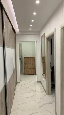 a hallway with white walls and a large tile floor at Jevtic in Vračar (historical)