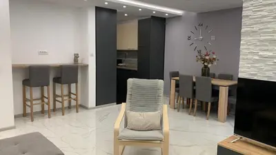 a kitchen and dining room with a clock on the wall at Jevtic in Vračar (historical)