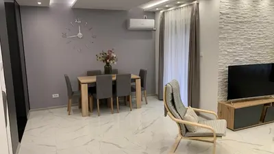 a dining room with a table and a clock on the wall at Jevtic in Vračar (historical)
