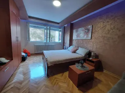 a small bedroom with a bed and a table at Cuca Apartments in Belgrade