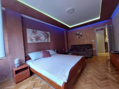 a bedroom with a large bed and a couch at Cuca Apartments in Belgrade