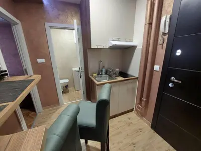 a small kitchen with a couch and a sink at Cuca Apartments in Belgrade