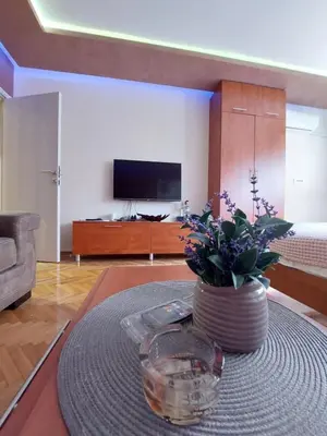 a living room with a vase of flowers on a table at Cuca Apartments in Belgrade