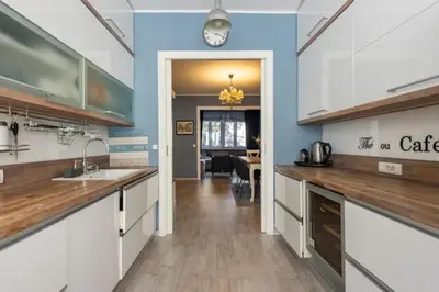 a kitchen with white cabinets and wooden counter tops at Indigo Apartment in Belgrade