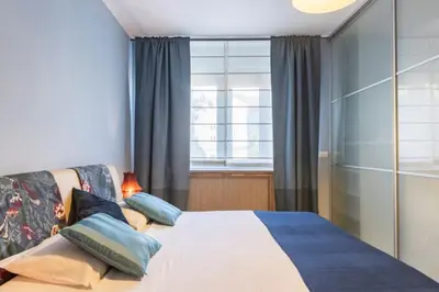 a bedroom with a bed with pillows and a window at Indigo Apartment in Belgrade