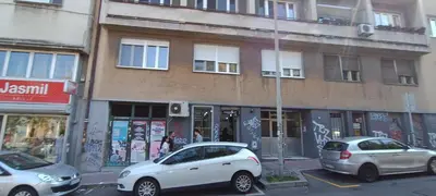 two cars parked in a parking lot in front of a building at Indigo Apartment in Belgrade