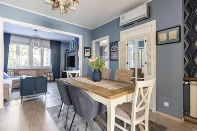 a dining room with a table and chairs and a living room at Indigo Apartment in Belgrade