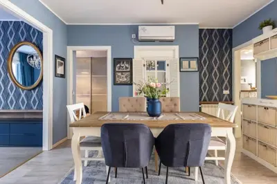 a dining room with blue walls and a wooden table and chairs at Indigo Apartment in Belgrade