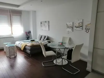 a bedroom with a bed and a table and chairs at Anejo A Blok in Novi Beograd