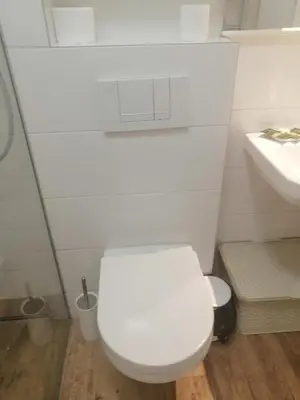 a white bathroom with a toilet and a sink at Anejo A Blok in Novi Beograd